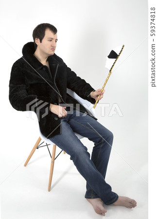 young man in a fur coat sitting in a white chair 59374818