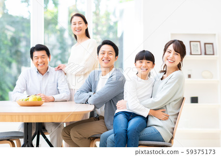 A smiling three generation family gathering at the dining room 59375173