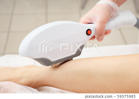 beautician does laser epilation on leg back part closeup beautician does laser epilation on leg back part closeup 59375985