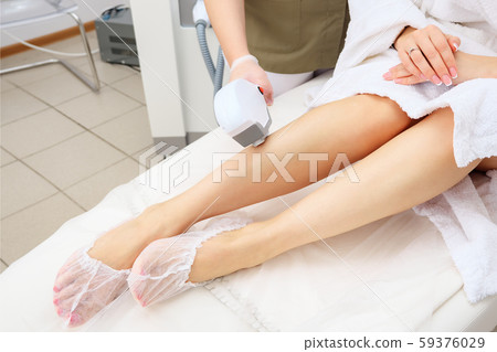 nurse does laser epilation on girl leg back part top view nurse does laser epilation on girl leg back part top view 59376029