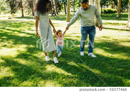 Family of mother, father, and son walking in the park together Family of mother, father, and son walking in the park together 59377466