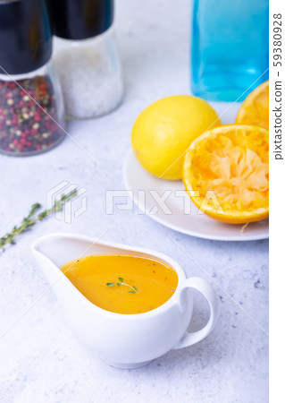 Orange sauce for duck (poultry) in a white gravy boat. Close-up, selective focus. 59380928
