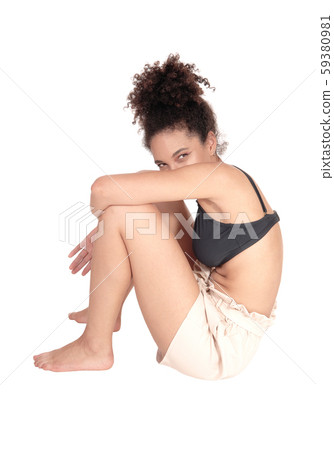 Beautiful multi-racial woman sitting on the floor Beautiful multi-racial woman sitting on the floor 59380981