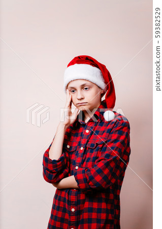 bored and pensive kid in christmas hat bored and pensive kid in christmas hat 59382529