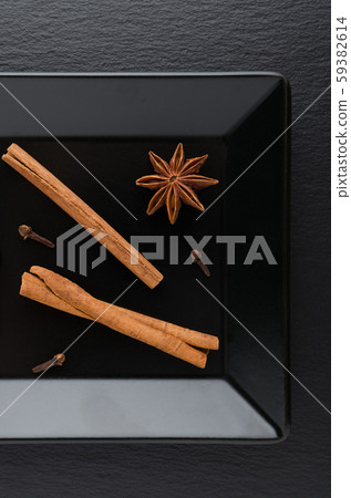 cinnamon sticks, clove and anise on black plate cinnamon sticks, clove and anise on black plate 59382614