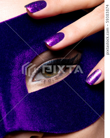 Woman's fingers with blue nails about eye. Macro 59383874