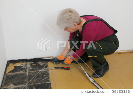 Old vinyl tiles removal from floor in a room or 59385326
