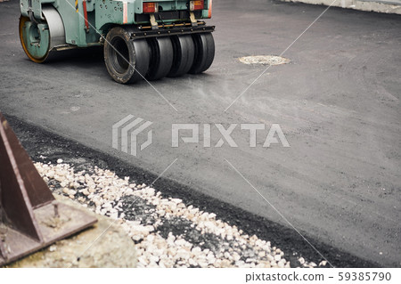 Asphalt Compactors is carrying out road repair work. Laying new asphalt. Large heavy machinery Asphalt Compactors is carrying out road repair work. Laying new asphalt. Large heavy machinery 59385790