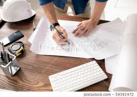 Hands of modern engineer with pencil drawing sketch of building construction 59391472