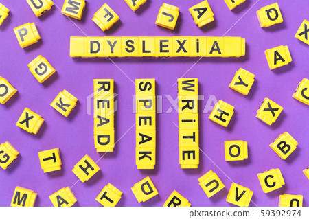 Dyslexia word yellow on pink purple with scattered letters cubes 59392974