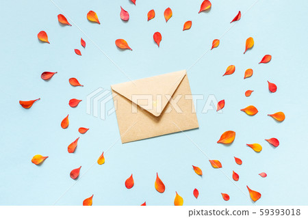 Paper envelope with small orange and red autumn leaves on a blue background. 59393018