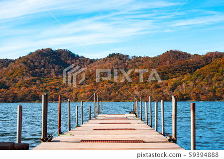 Lake and mountain landscape with a pier in the center 59394888