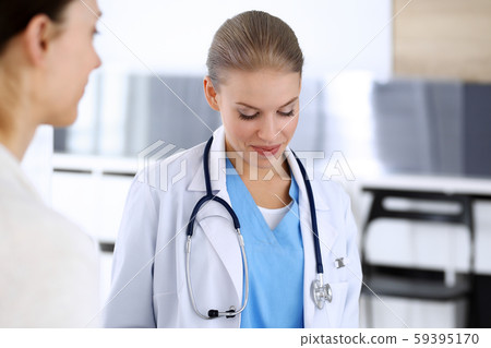 Doctor and patient during consultation. Physician at work filling up medication history record while Doctor and patient during consultation. Physician at work filling up medication history record while 59395170