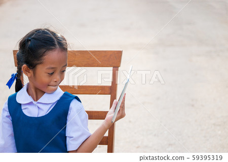 Happy little girl holding tablet PC outdoors in Happy little girl holding tablet PC outdoors in 59395319