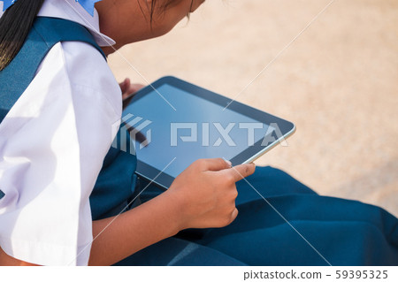 Happy little girl holding tablet PC outdoors in Happy little girl holding tablet PC outdoors in 59395325