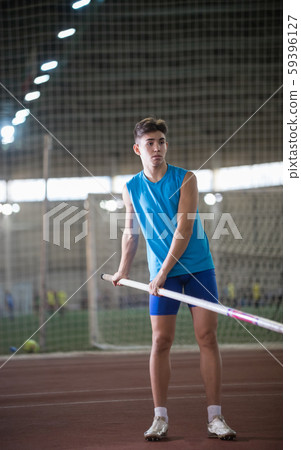 Pole vaulting - young guy in a blue suit is holding a pole Pole vaulting - young guy in a blue suit is holding a pole 59396127