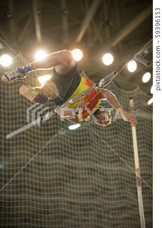 Pole vaulting - man is jumping over the bar and is going to let go of the pole Pole vaulting - man is jumping over the bar and is going to let go of the pole 59396153