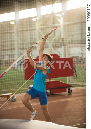 Pole vaulting - man in blue shirt is going to jump with pole Pole vaulting - man in blue shirt is going to jump with pole 59396157