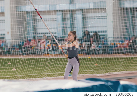 Pole vaulting - woman with ponytail is running with a pole Pole vaulting - woman with ponytail is running with a pole 59396203