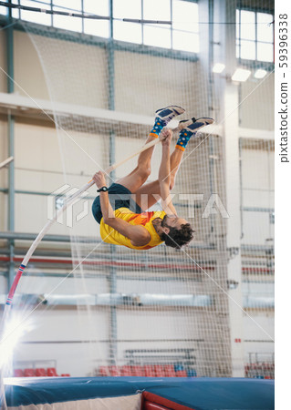 Pole vaulting - man is reaching the bar on the pole Pole vaulting - man is reaching the bar on the pole 59396338