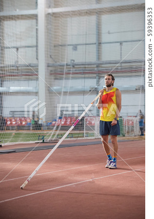 Pole vaulting - man with a beard is standing with a pole Pole vaulting - man with a beard is standing with a pole 59396353