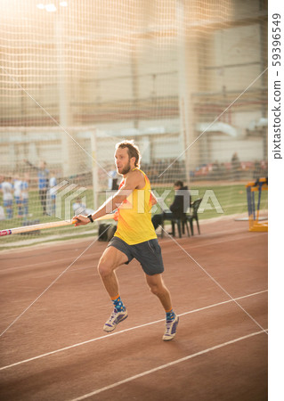 Pole vaulting in the sports stadium - an athletic man running on the track Pole vaulting in the sports stadium - an athletic man running on the track 59396549
