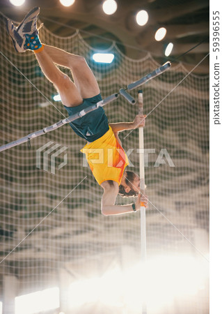 Pole vaulting training in the sports stadium - an athletic man jumping over the bar Pole vaulting training in the sports stadium - an athletic man jumping over the bar 59396555