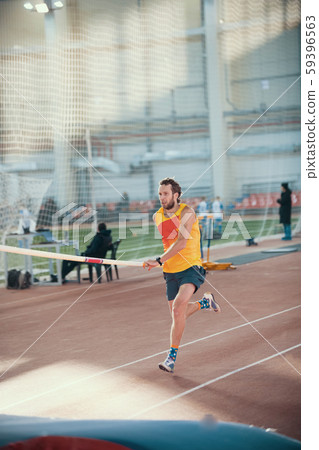 Pole vaulting in the sports stadium - a sportive man running on the track Pole vaulting in the sports stadium - a sportive man running on the track 59396563