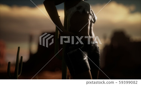 woman in torn shirt standing by cactus in desert