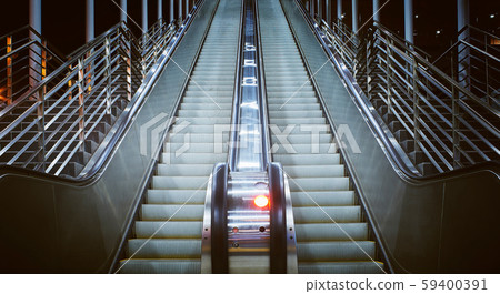 Low angle and close up view at a long escalator in public building. night scene . Low angle and close up view at a long escalator in public building. night scene . 59400391