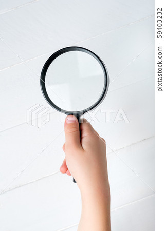 Magnifier in a children's hand on a white Magnifier in a children's hand on a white 59403232