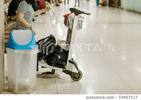 Blue cover transparent trashcan for increasing safety measures placed on the floor in the airport. Blue cover transparent trashcan for increasing safety measures placed on the floor in the airport. 59407517