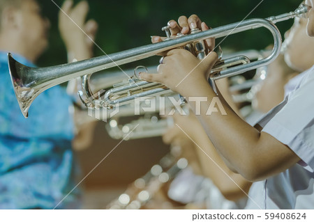 Male student with friends blow the trumpet with the band for performance on stage at night. Male student with friends blow the trumpet with the band for performance on stage at night. 59408624