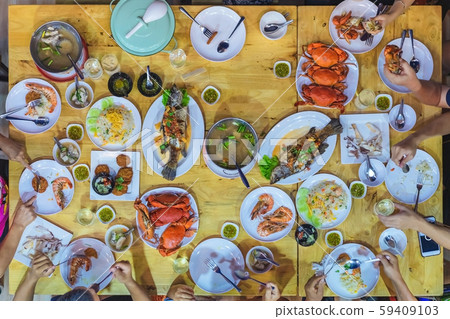 Top view of Happiness family enjoy eating with a variety of seafood dishes on dinner. Top view of Happiness family enjoy eating with a variety of seafood dishes on dinner. 59409103