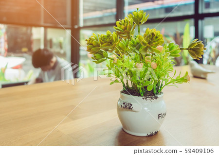 Artificial plants or plastic tree on table for decoration and welcome for customers in coffee shop. Artificial plants or plastic tree on table for decoration and welcome for customers in coffee shop. 59409106
