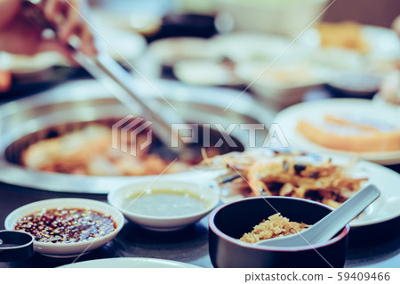 People grilling meat on a smokeless barbecue grill in a restaurant. Selective focus on rice. 59409466
