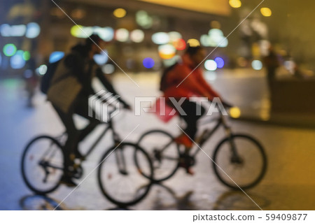 Silhouettes of abstract unrecognizable young couple, riding bikes, night city, illumination bokeh Silhouettes of abstract unrecognizable young couple, riding bikes, night city, illumination bokeh 59409877