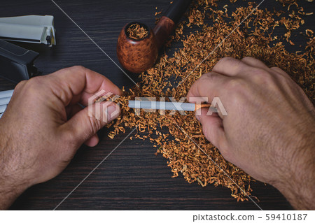 man makes a cigarette, hands closeup man makes a cigarette, hands closeup 59410187