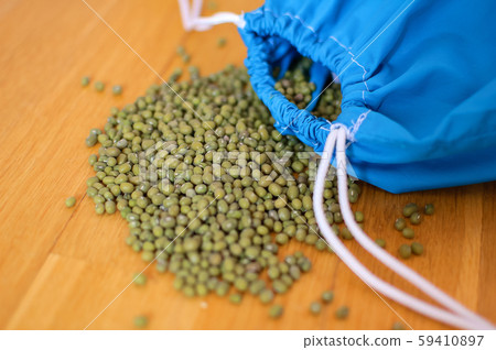 Close up of green mung bean vigna radiata in blue reusable package on wooden background. Eco 59410897