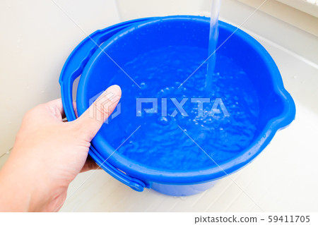 Hand drawing water into the bucket 59411705
