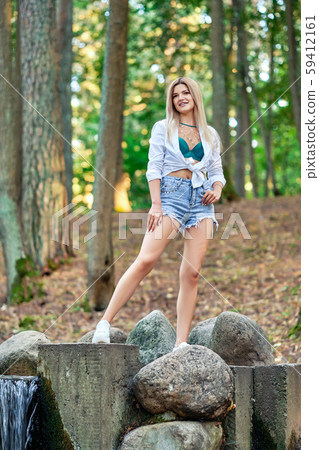 Girl walking in park along stones surrounding Girl walking in park along stones surrounding 59412161