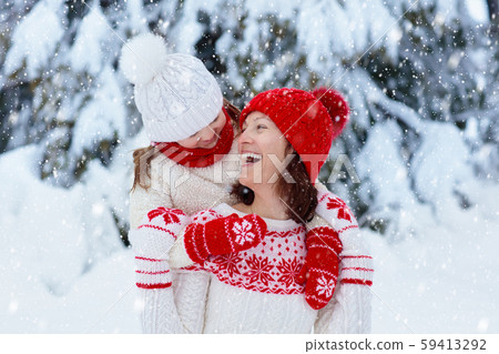 Mother and child in knitted winter hats in snow. Mother and child in knitted winter hats in snow. 59413292
