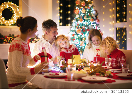 Family with kids having Christmas dinner at tree Family with kids having Christmas dinner at tree 59413365