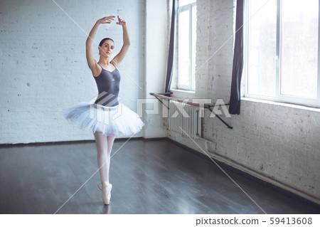 Young ballet dancer practice standing on toes in studio active lifestyle Young ballet dancer practice standing on toes in studio active lifestyle 59413608