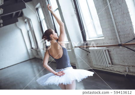 Young ballet dancer move looking out the window in studio active lifestyle Young ballet dancer move looking out the window in studio active lifestyle 59413612