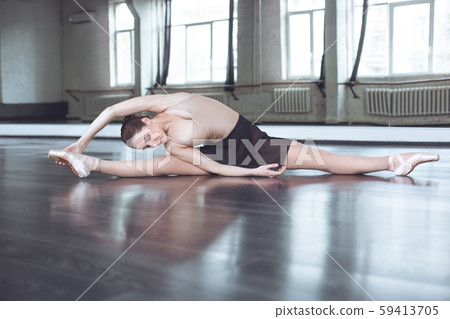 Young ballet dancer practice legs stratching in studio active lifestyle Young ballet dancer practice legs stratching in studio active lifestyle 59413705