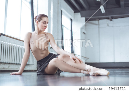 Young ballet dancer sitting thoughtful in studio active lifestyle Young ballet dancer sitting thoughtful in studio active lifestyle 59413711