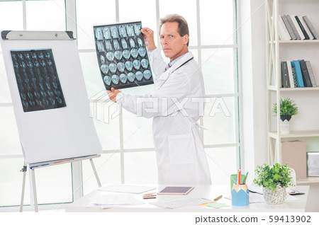 Senior doctor at his office in hospital holding rentgen Senior doctor at his office in hospital holding rentgen 59413902