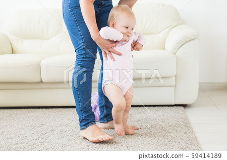 Little baby girl first steps with the help of mom Little baby girl first steps with the help of mom 59414189