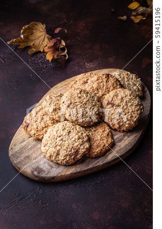Homemade oatmeal cookies on a wooden cutting board. Dark background. Rustic style 59415196